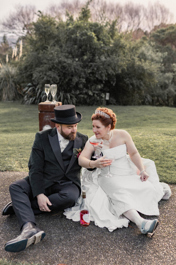 Close-up wedding photograph from a second perspective showing Sam and Jesse toasting and sharing a joyful moment during their Akaroa wedding.